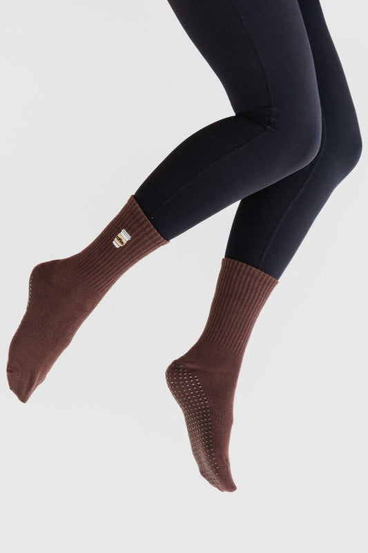 Brown socks worn with black leggings on a light gray background