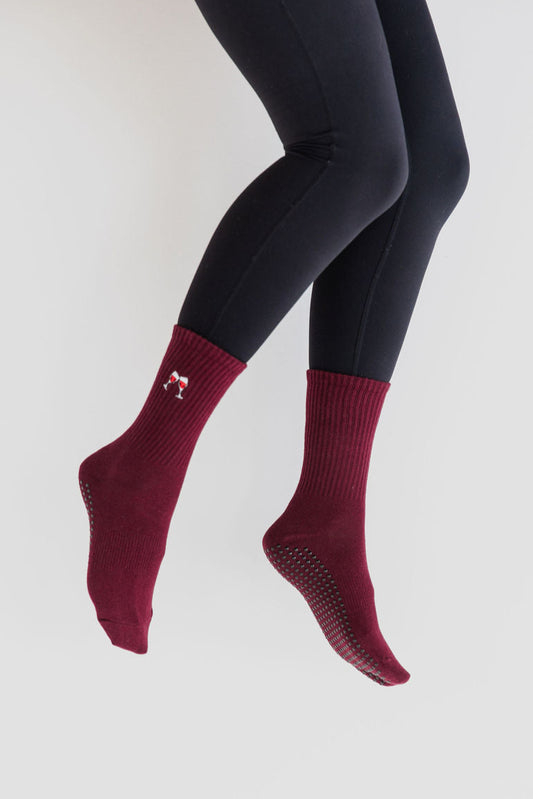 Maroon socks worn with black leggings on a white background