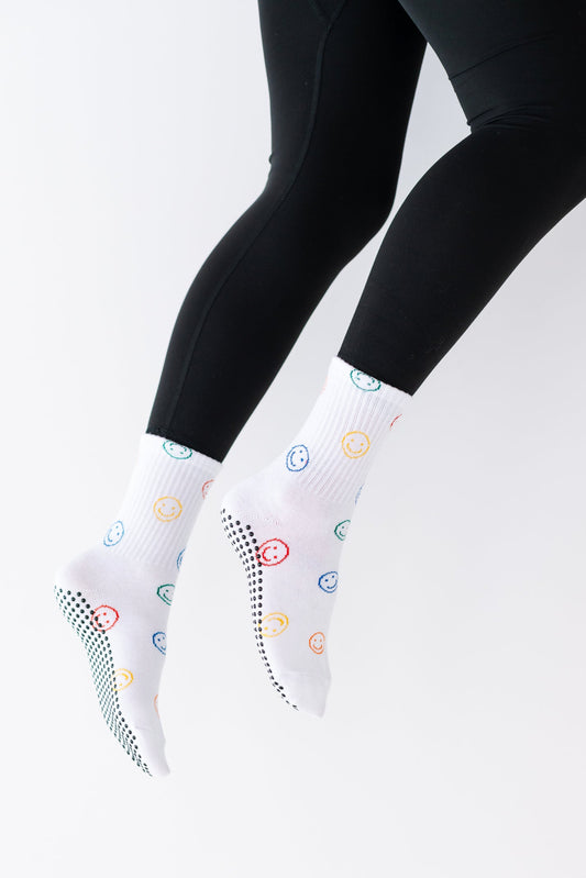 White socks with colorful patterns worn by a person against a white background