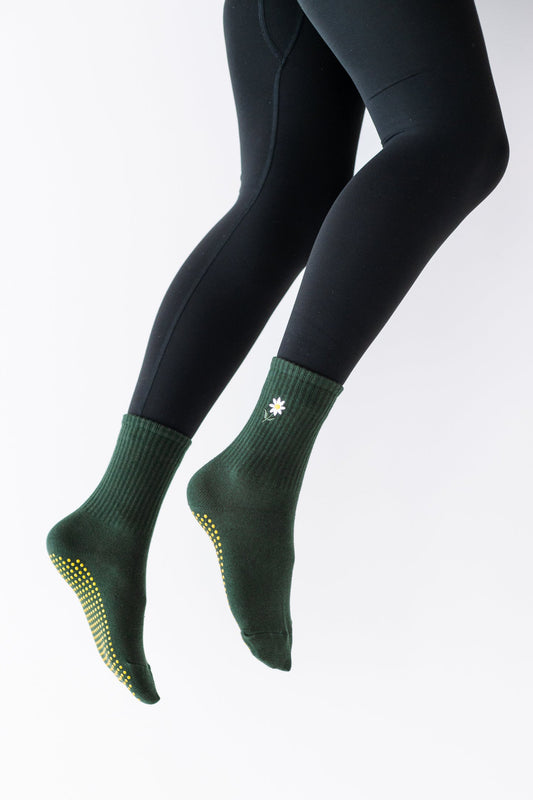 A pair of green grip socks designed for workouts, showing the foot area with non-slip soles.