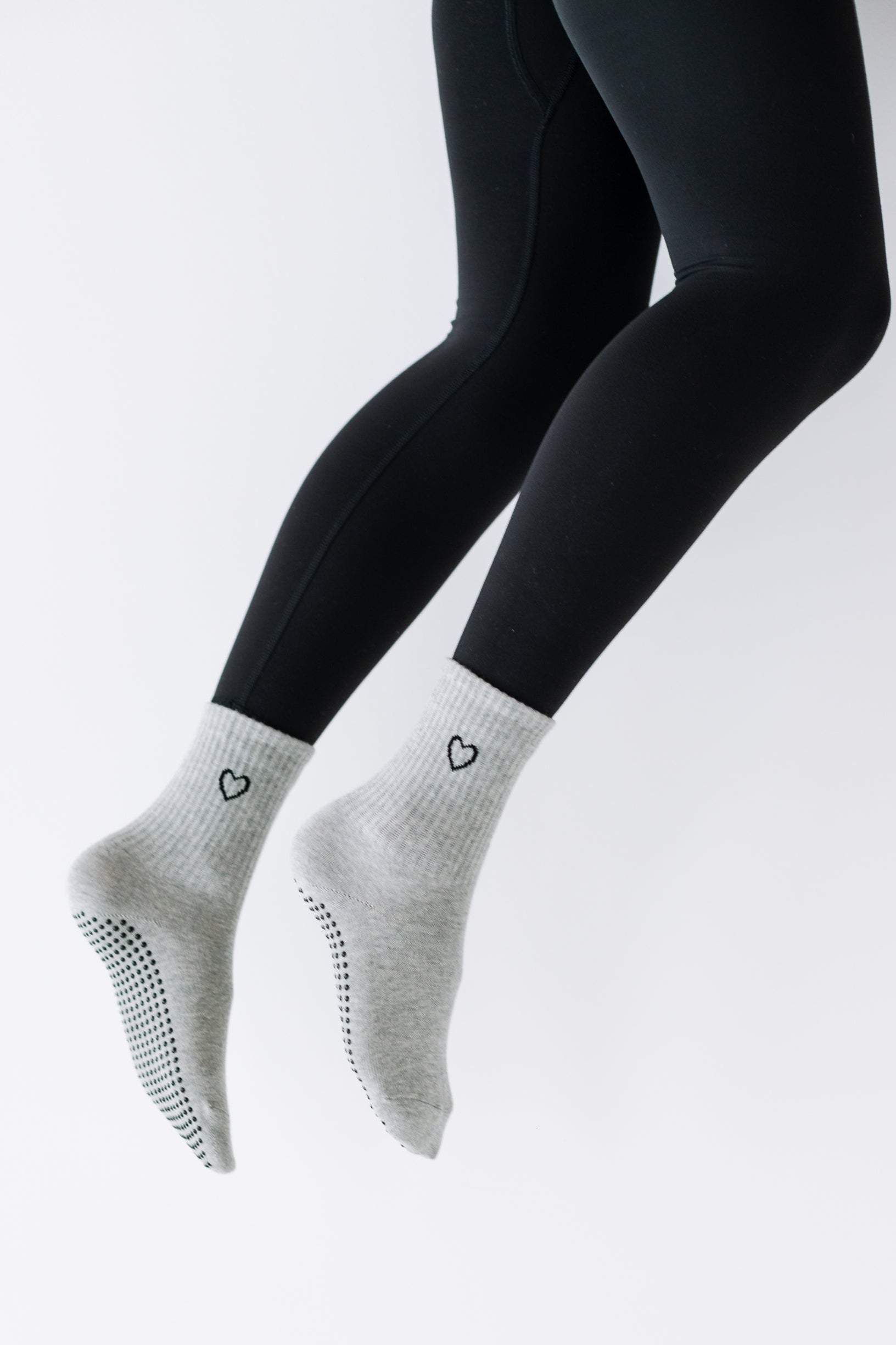 Gray ankle socks with black heart designs on a white background
