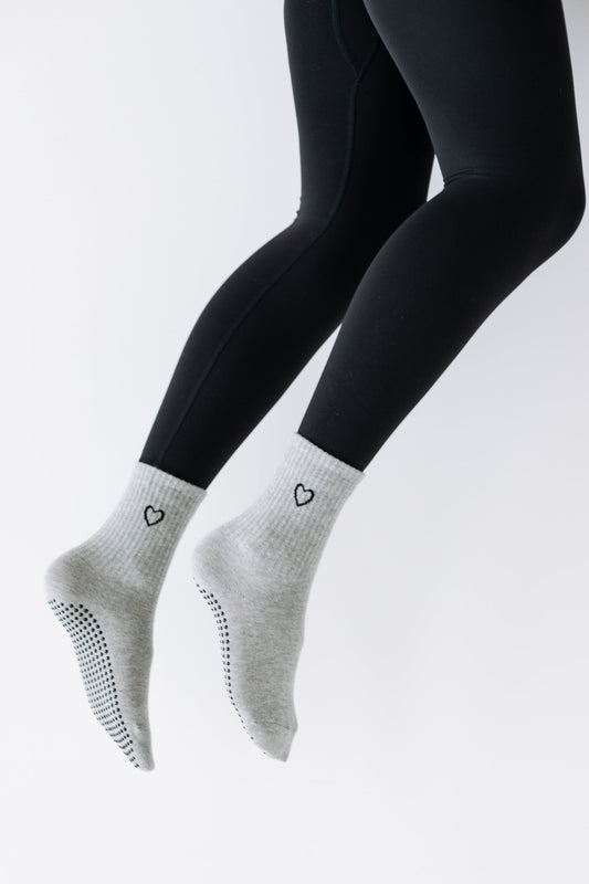 Gray ankle socks with black heart designs on a white background
