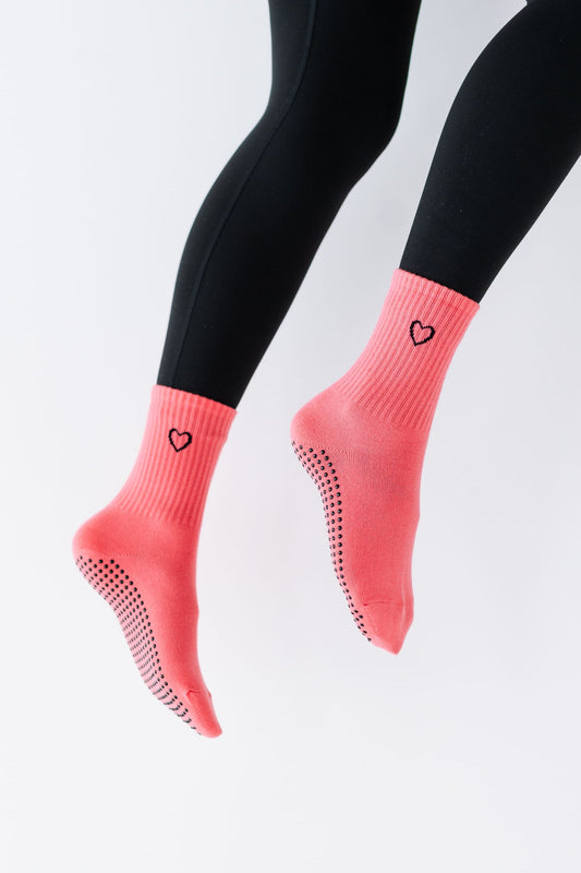 Pink ankle socks with black leggings on a light gray background