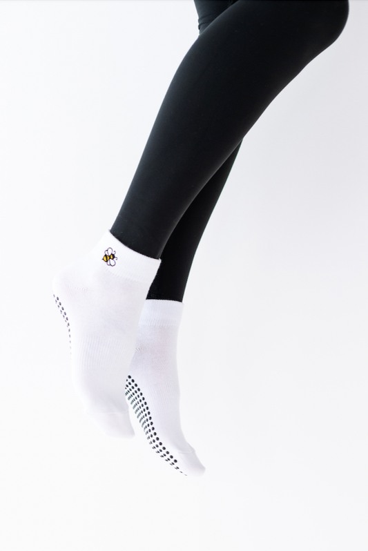 White socks with black accents worn with black leggings on a white background