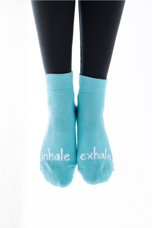 Light blue socks with 'inhale' and 'exhale' text on a white background